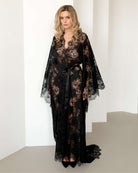 Full-body view of model in sheer black lace robe against white background – KÂfemme