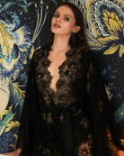 Waist-up shot focusing on the exquisite floral lace patterns and the deep V-neckline of the black evening robe.