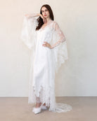 Bride adjusting lace robe sash, side view
