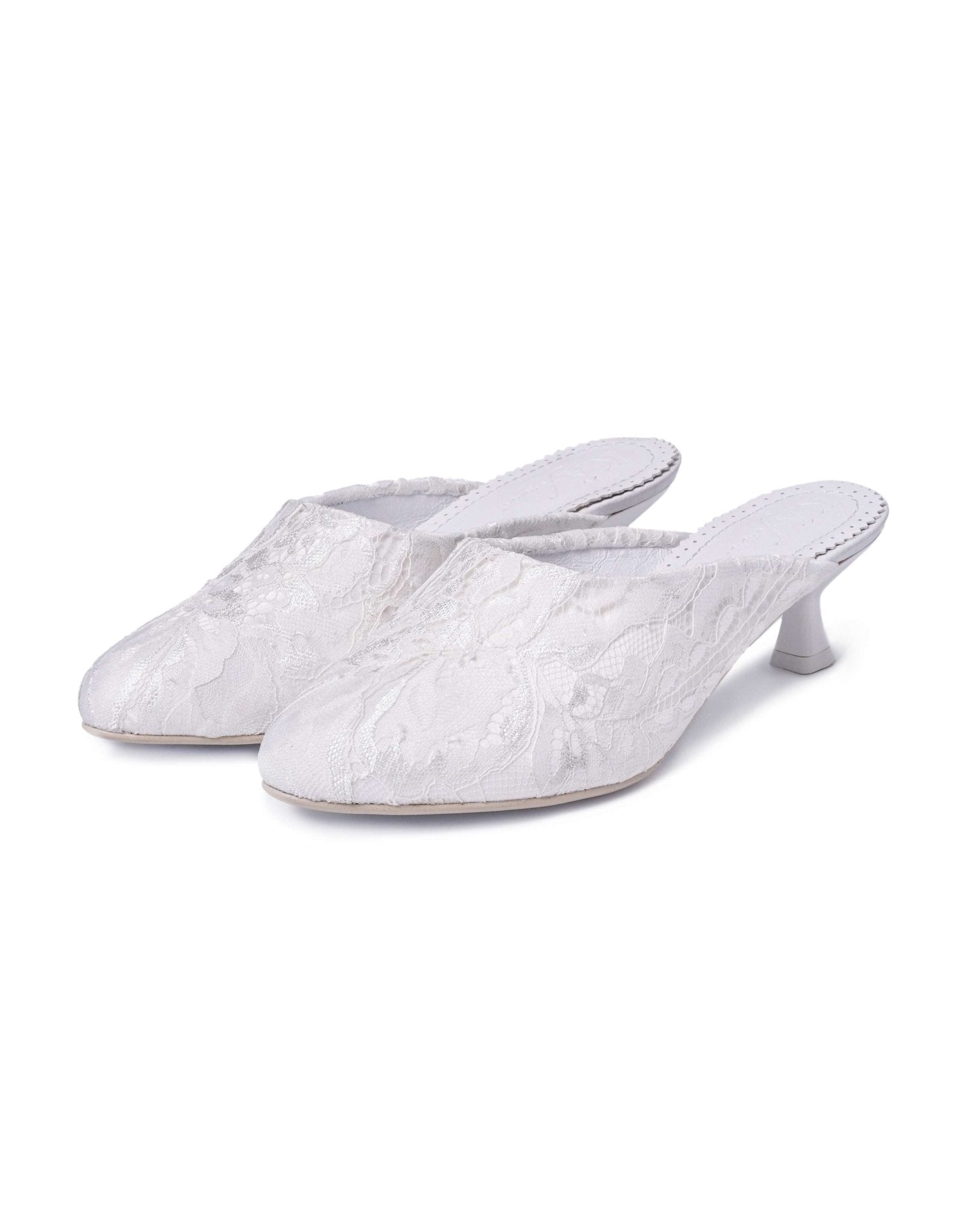 A snapshot of two heeled slippers standing positioned next to each other on a seamless white surface.