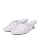 A snapshot of two heeled slippers standing positioned next to each other on a seamless white surface.
