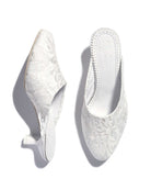 A detailed view of the slippers on a white background, displaying one shoe standing upright and the other placed flat.