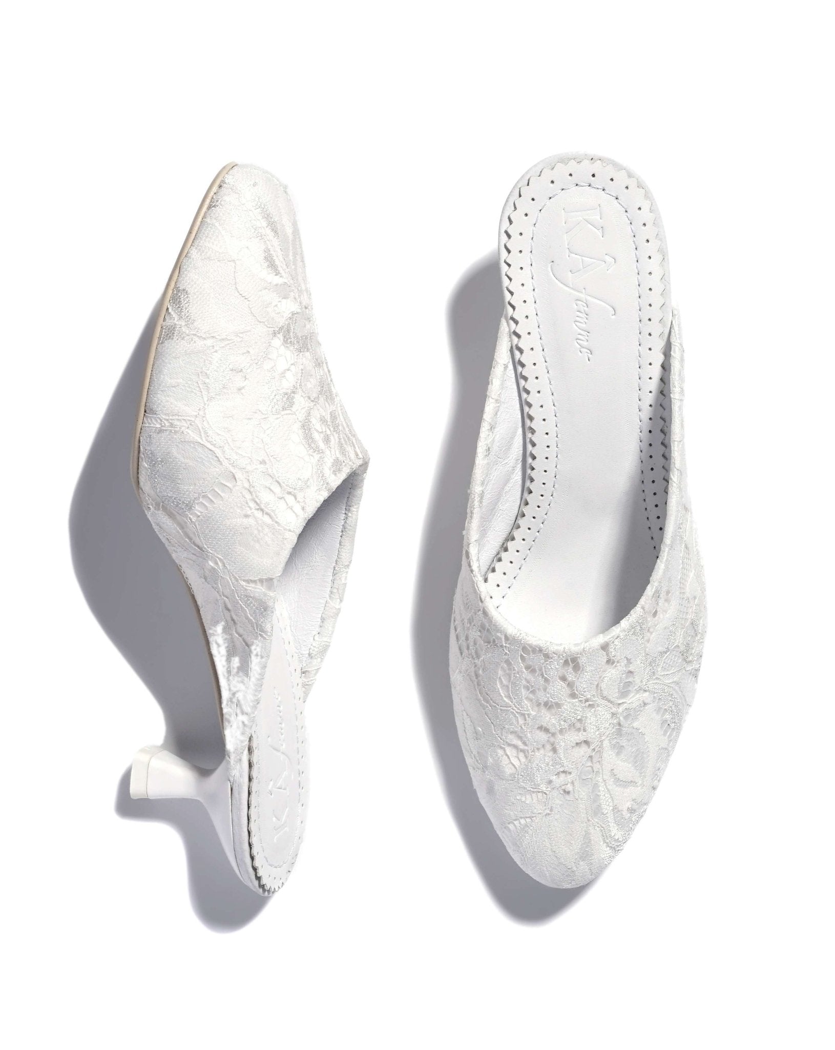 A detailed view of the slippers on a white background, displaying one shoe standing upright and the other placed flat.