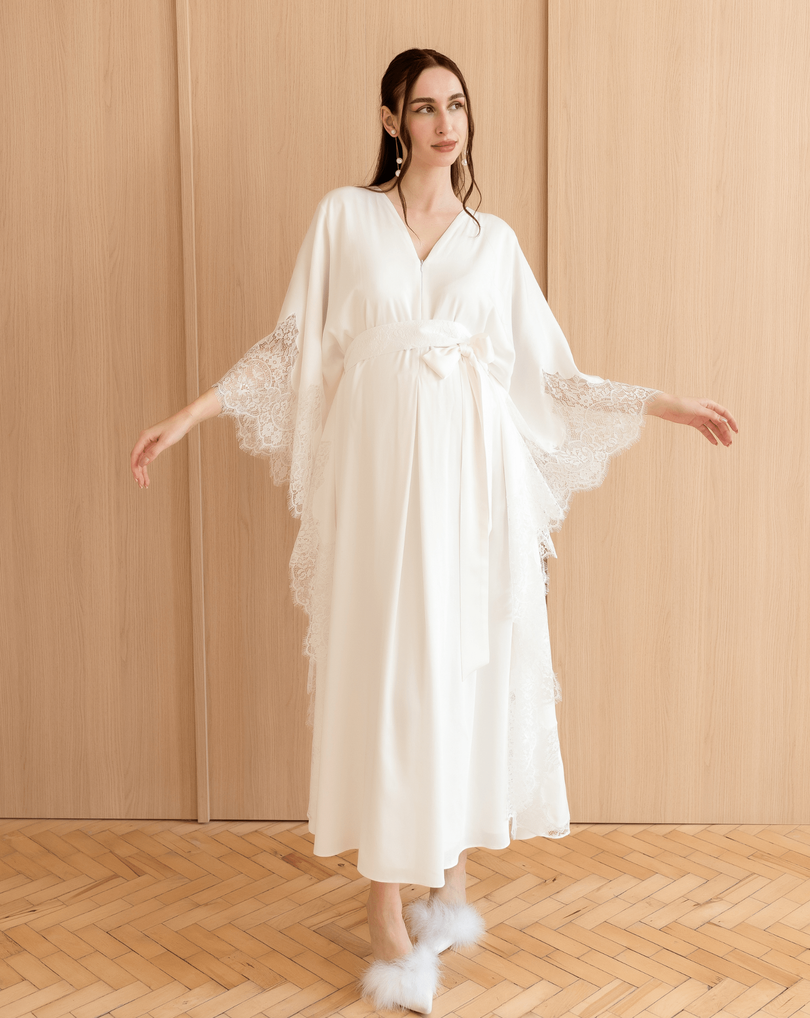 A flowing Cotton Kaftan shown in a pose with raised arms, highlighting the loose fit and decorative side lace.
