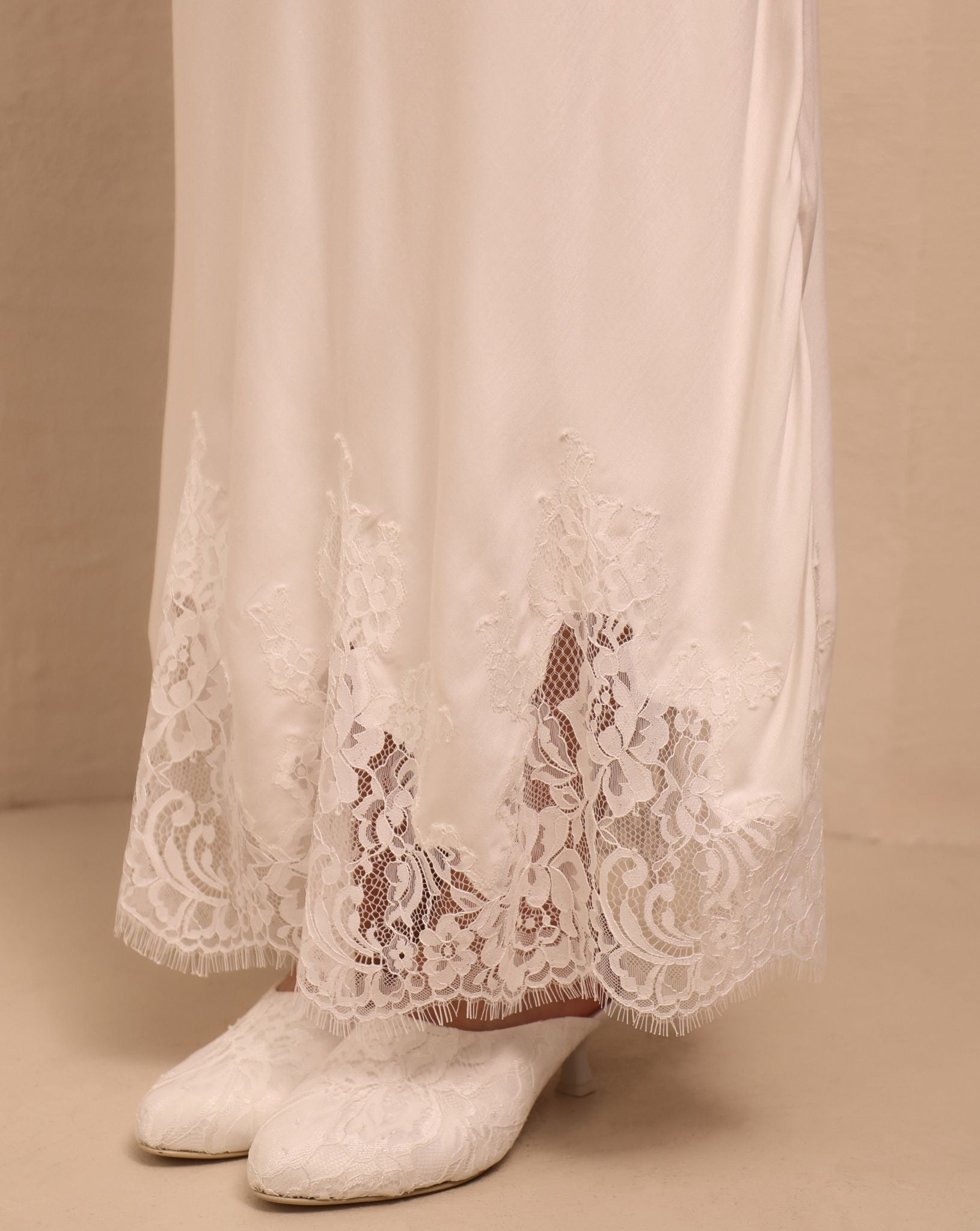A detailed close-up of the nightgown’s hem, showcasing the smooth finish and the light texture of the fabric.
