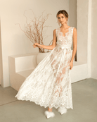 Elegant woman gracefully tossing the hem of her white Bridal Nightgown, showcasing the flowing lace fabric.