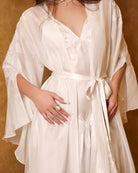 Detailed shot of the belted robe, focusing on the silk tie and the exquisite craftsmanship of the lace-trimmed sleeves.