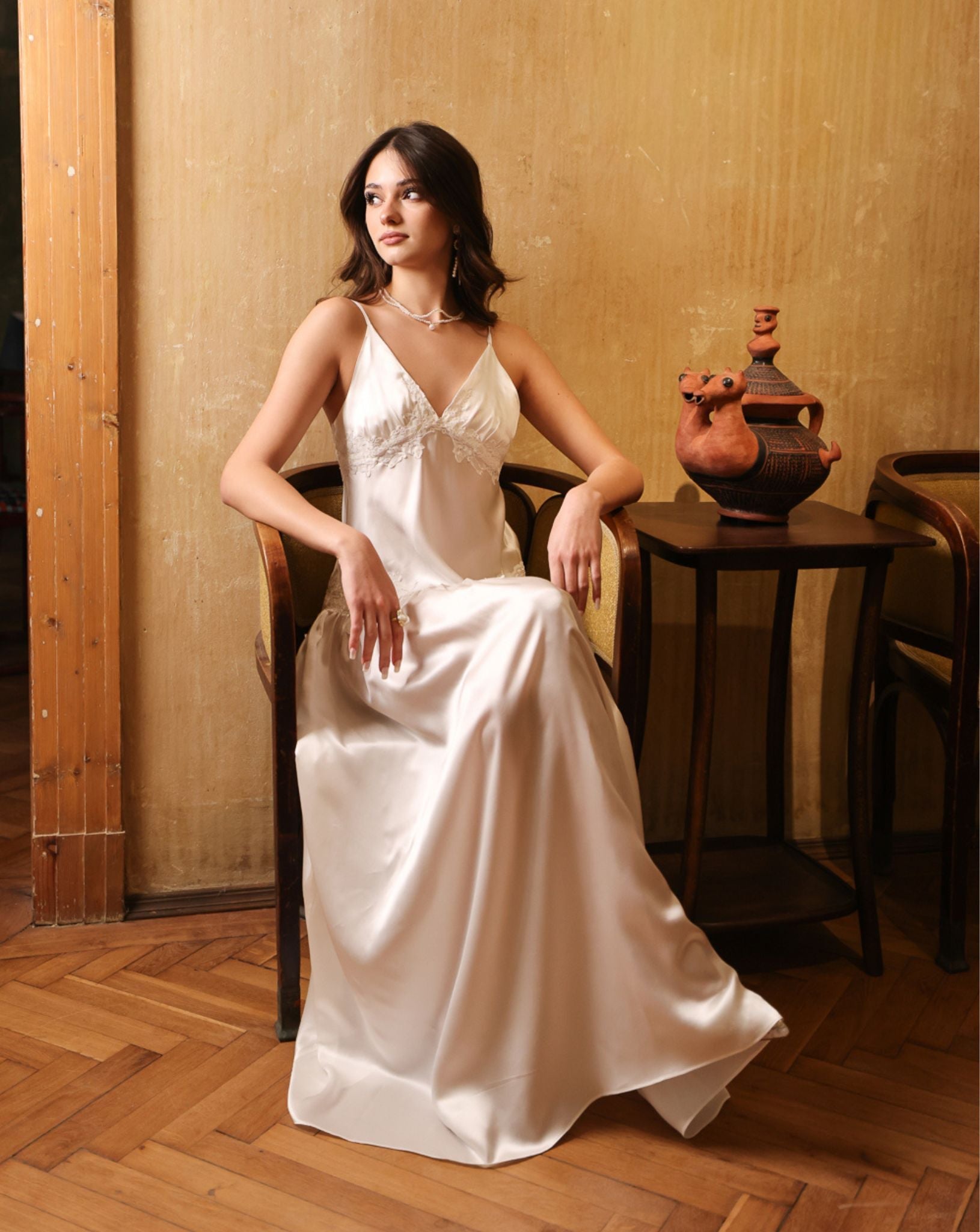 Artistic shot of a silk satin nightdress while sitting on a chair, capturing a moment of quiet luxury and elegance.