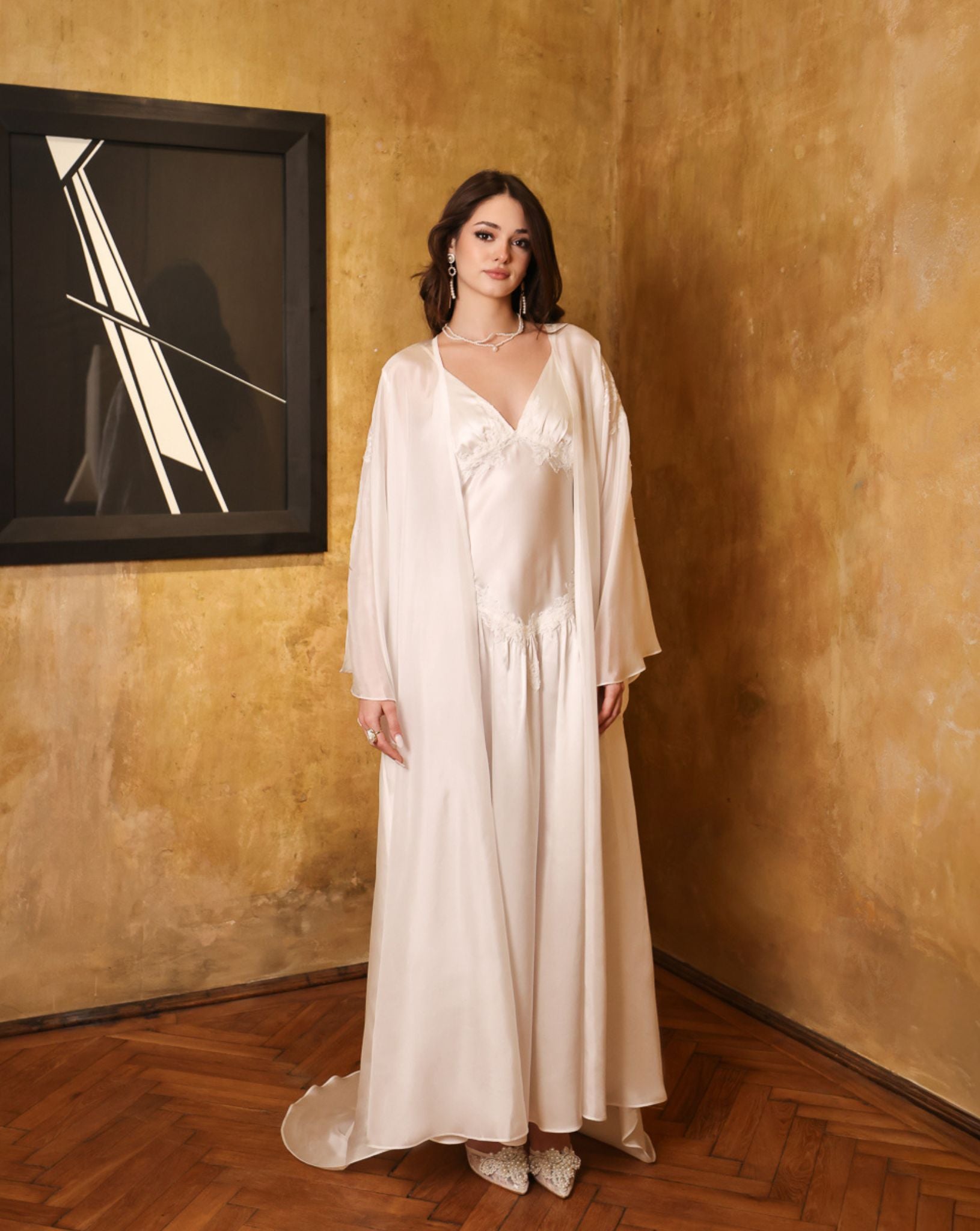 Elegant pose in the complete silk set with a raised hand, capturing the play of light on the sheer chiffon layers.