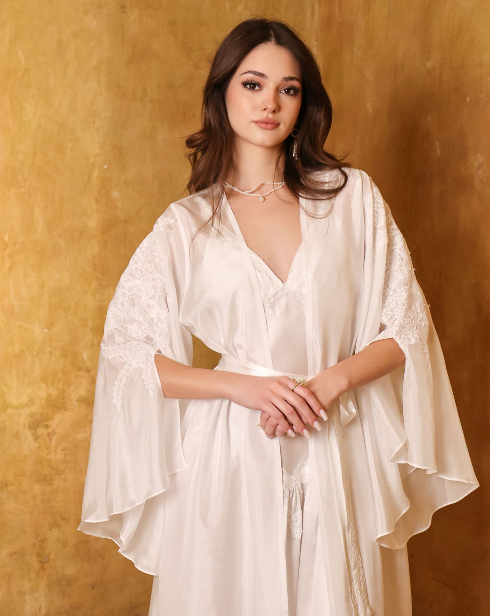 Portrait-focused shot of the bridal ensemble, showcasing the refined lace embellished sleeves and soft silk texture.