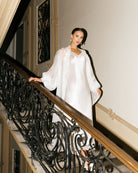 Silk Robe and Nightgown Set in motion on a staircase, capturing the weightless movement of the 100% mulberry silk.
