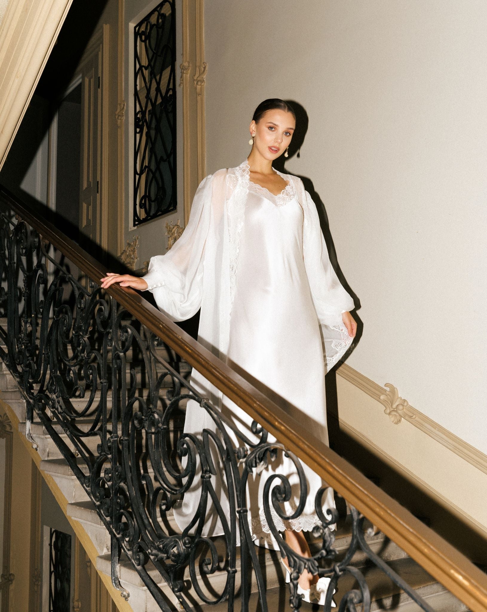 Silk Robe and Nightgown Set in motion on a staircase, capturing the weightless movement of the 100% mulberry silk.