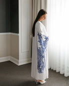 Side full-length pose focusing on the wide sleeves adorned with delicate and intricate lace embroidery.