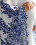 Close-up of hands on a pregnancy bump, showcasing the elegant lace details and high-quality craftsmanship of the sleeves.