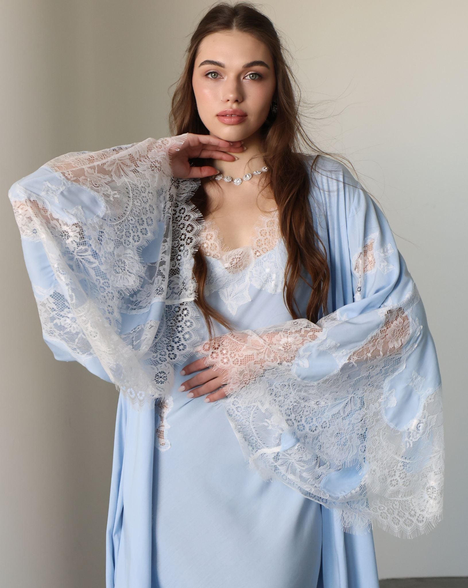 A mid-length shot focusing on the exquisite lace detailing and the elegant wide sleeves of the robe.