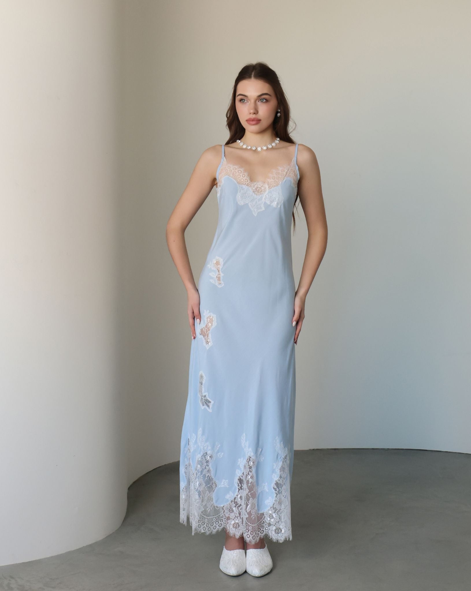 Frontal view of the nightgown adorned with delicate lace cutouts that trace the silhouette with artistic charm.