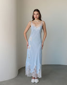 Frontal view of the nightgown adorned with delicate lace cutouts that trace the silhouette with artistic charm.