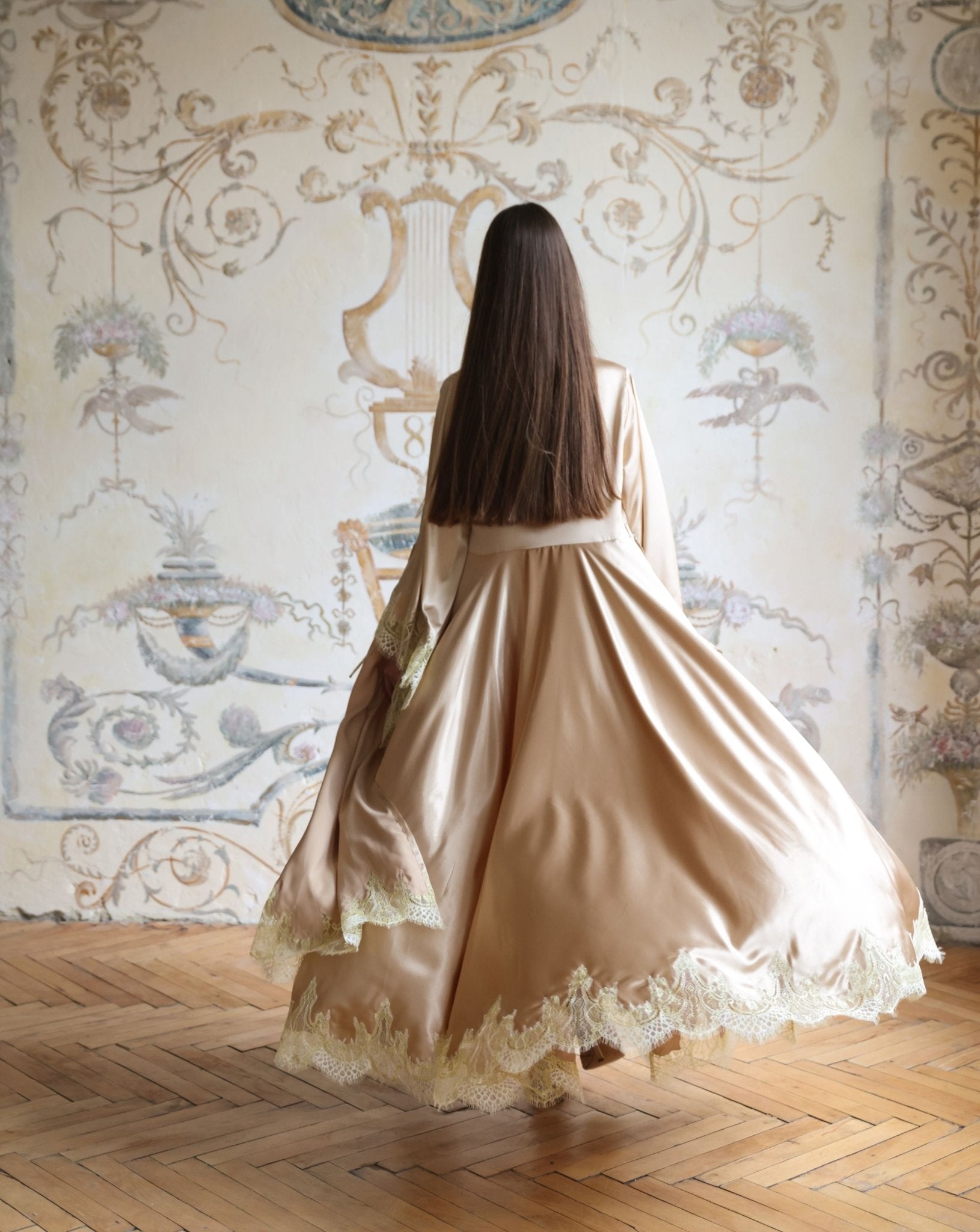 Rear view of the flowing robe in motion, showcasing the wide sleeves and the elegant drape of the satin.