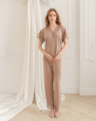 A full-length pose with hands on the hips, displaying the matching pants with a waist ribbon for effortless comfort.