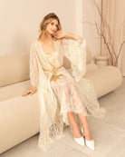 Bride sitting on beige sofa in embroidered robe and satin gown - Kafemme Loungewear