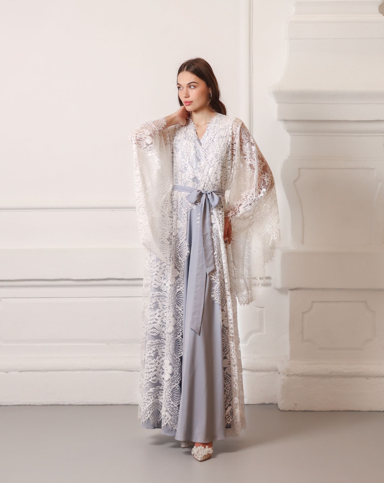 The maternity robe and nightgown set in a tied look, with one hand on the hips and the other near the neck.