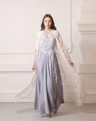 A dynamic walking shot with the sheer lace robe billowing softly behind, creating a romantic trailing effect.