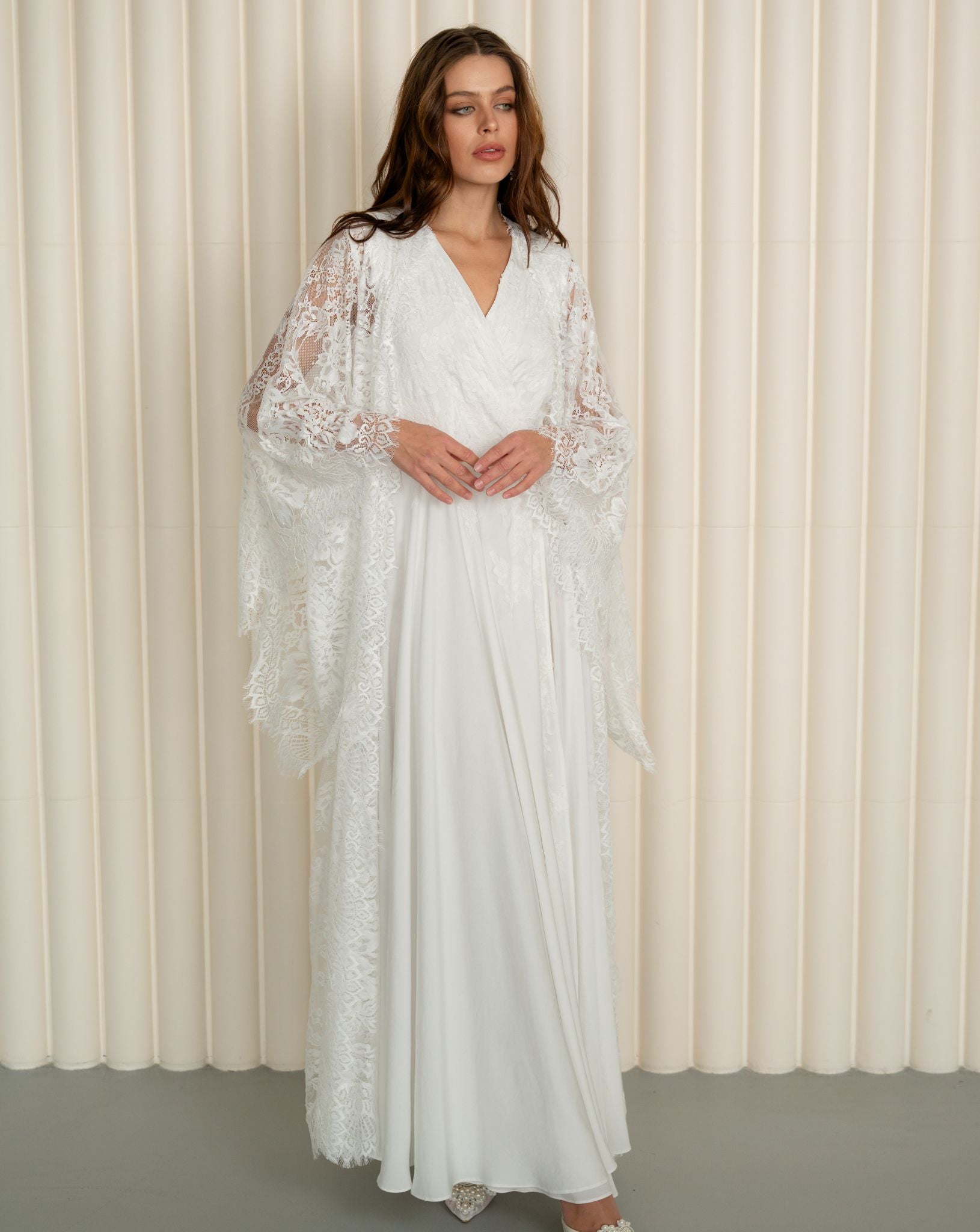 A static shot of the maternity robe and nightgown set with the woman's hands gently resting on her belly.