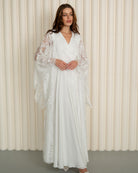 A static shot of the maternity robe and nightgown set with the woman's hands gently resting on her belly.
