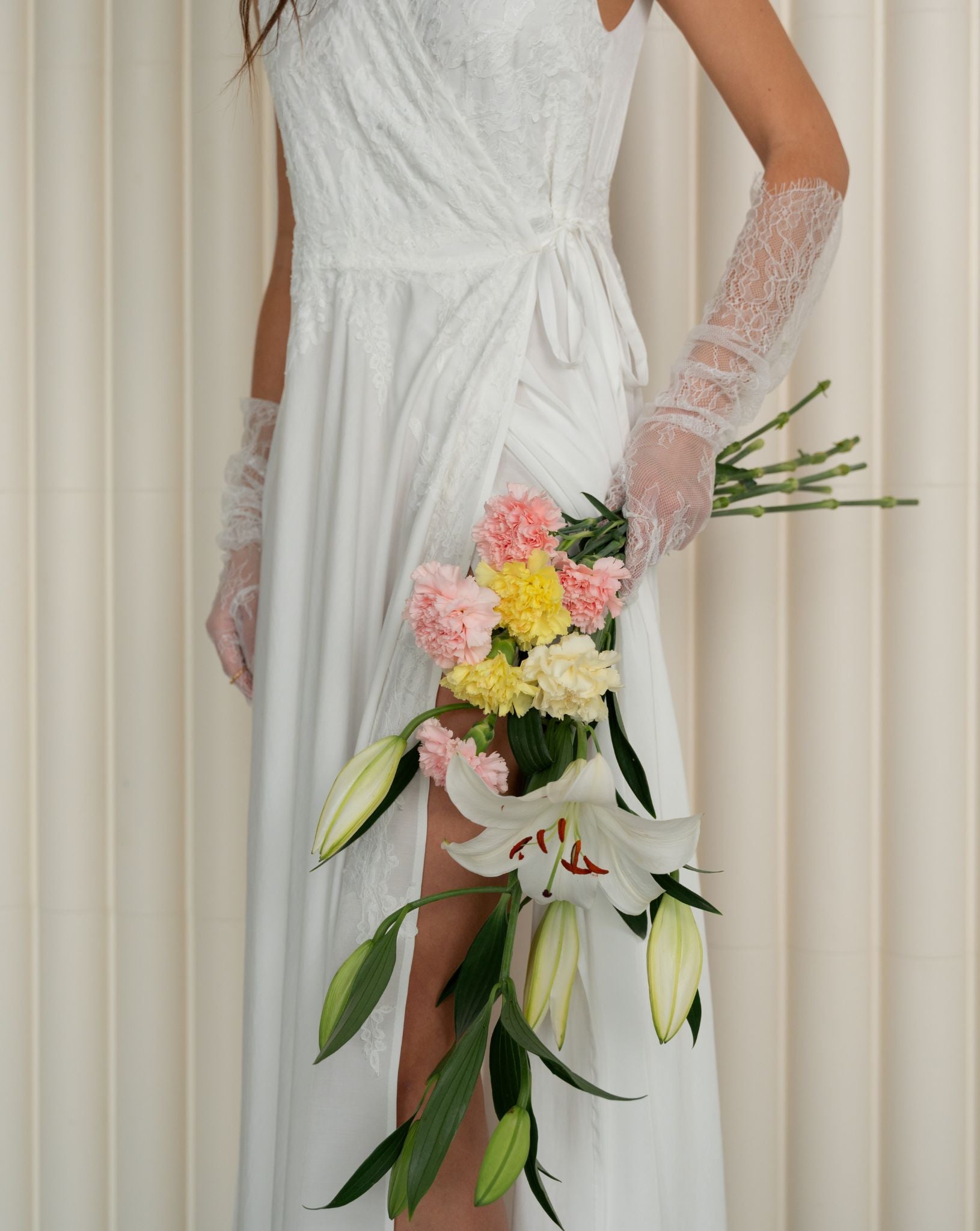 An artistic photograph of a woman wearing the nightwear while holding a delicate bouquet of flowers.