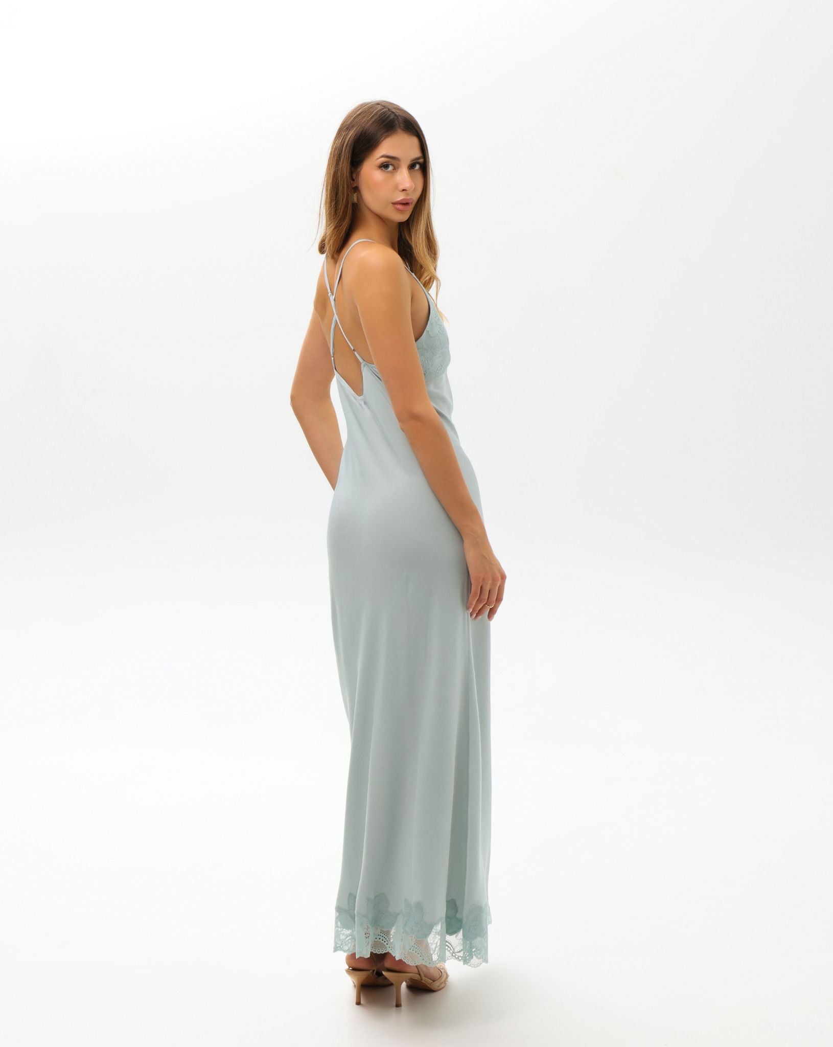 Side view of the sleeveless nightgown, showcasing the lace cutouts and the fluid silhouette that gently follows the body.