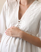 View of the lace-trimmed neckline and front buttons, designed for quick and easy nursing access during pregnancy.
