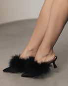 A mid-length shot of the Satin Slippers on the feet, highlighting the pointed-toe form and delicate feathers.