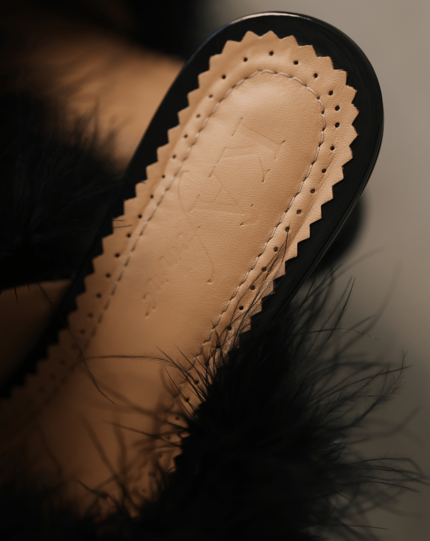 A detailed shot of the genuine leather insole, showcasing the brand's logo and soft padding for comfort.