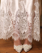 Close-up of the nightgown's hem, highlighting the delicate lace detailing and the gentle sheen of silk satin.