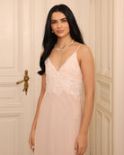 Mid-length shot focusing on the intricate lace at the neckline, illustrating the romantic restraint of the design.