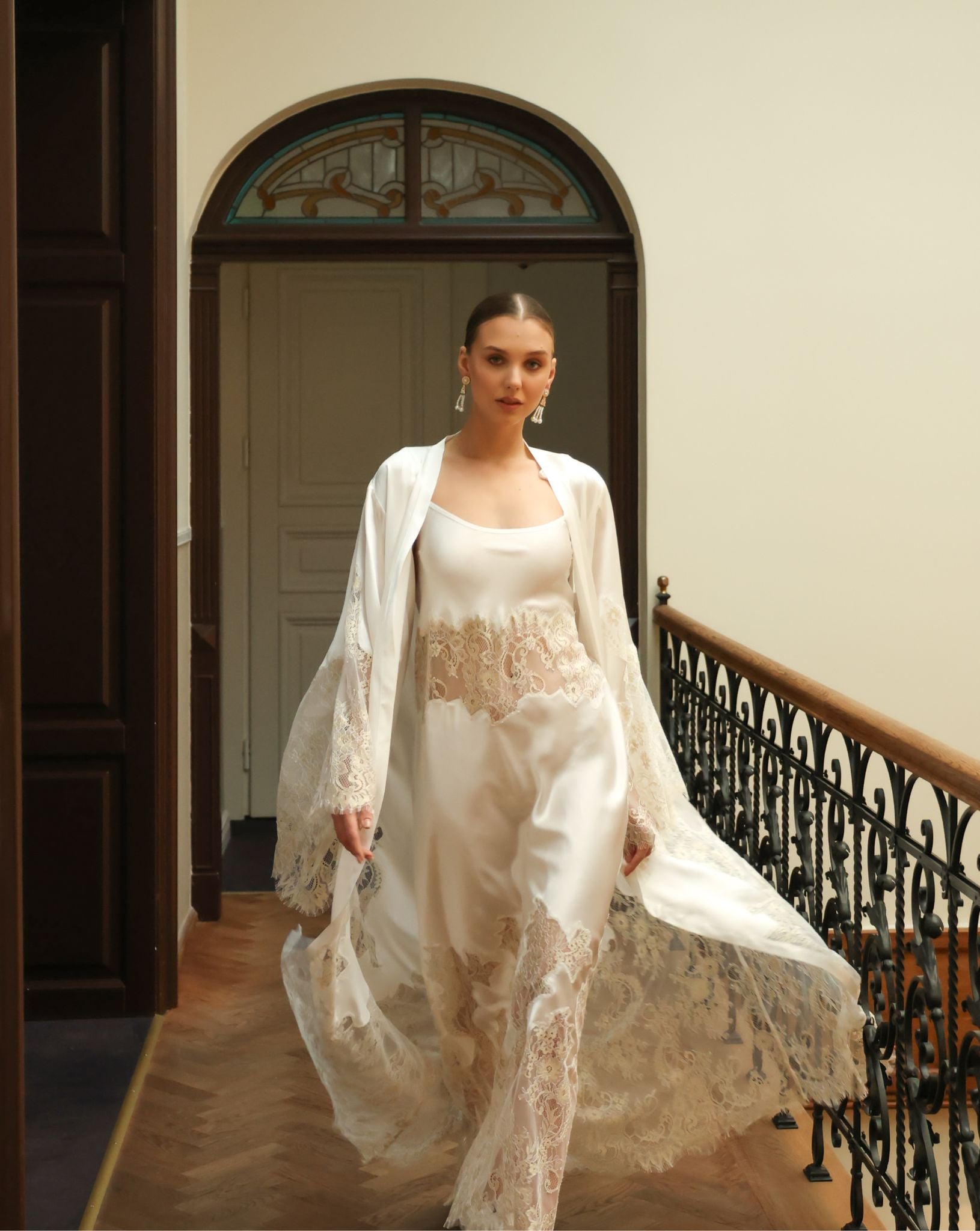 Dynamic shot of a white bridal ensemble in motion, capturing the ethereal elegance of the French lace design.
