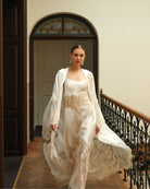 Dynamic shot of a white bridal ensemble in motion, capturing the ethereal elegance of the French lace design.