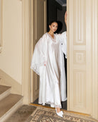 White Silk Robe and Nightgown Set shown by the doors in a full-length view, highlighting its modest and refined luxury.