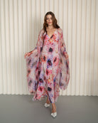 Full-length shot of a walking woman, featuring the airy movement of a floor-length sheer silk wrap-over robe.