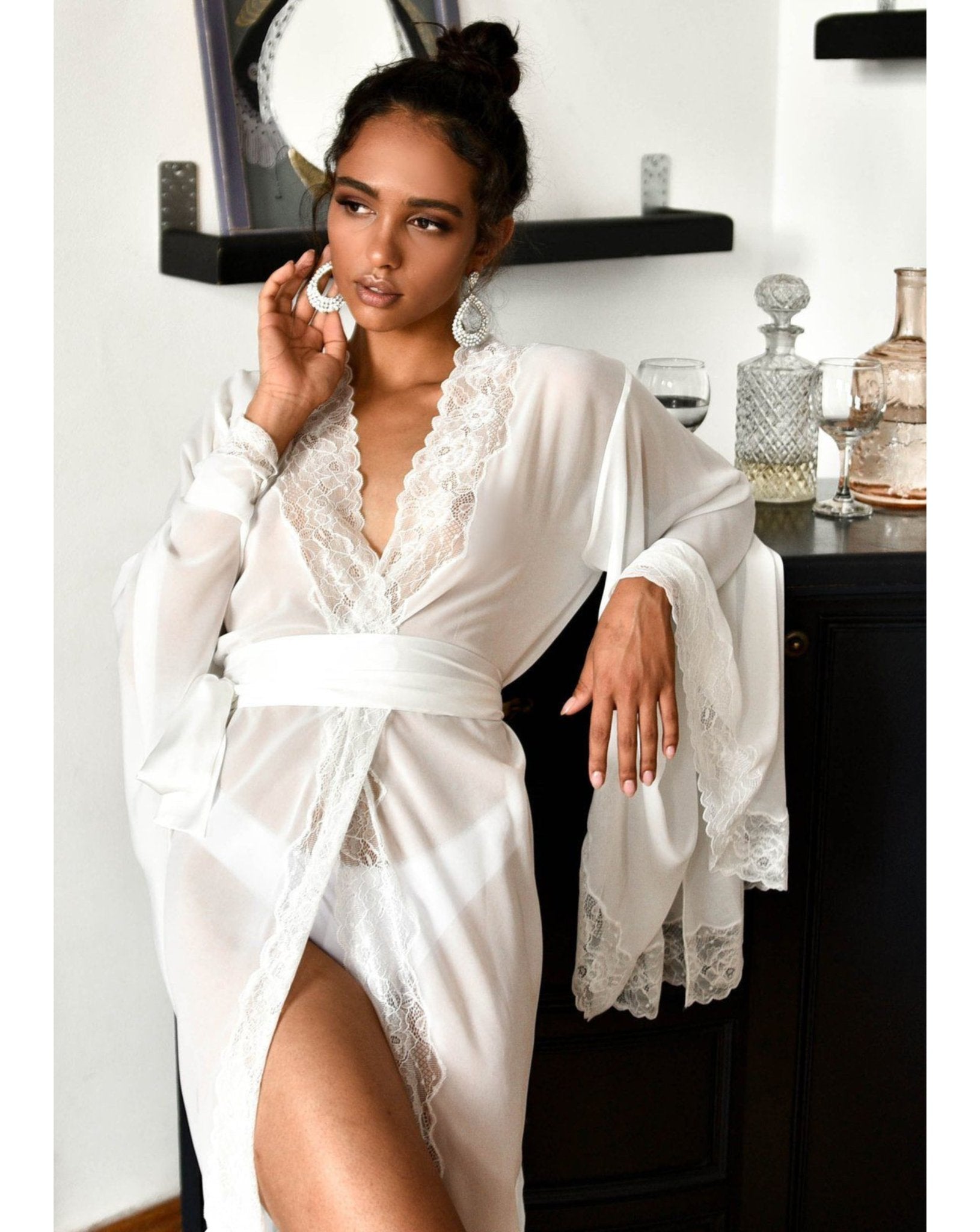 Woman in sheer chiffon robe smiling while standing near a mirror